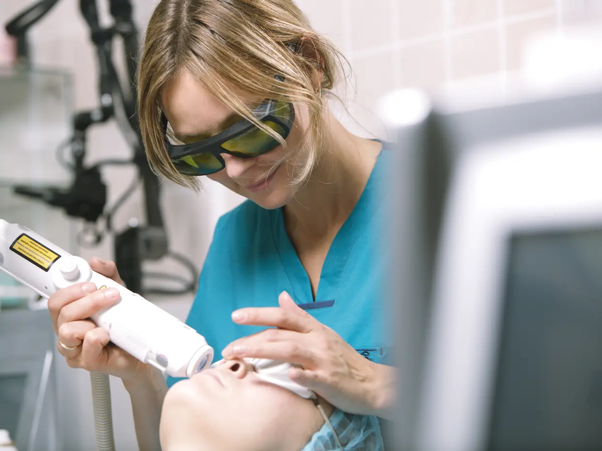 practitioner using laser on patient's face