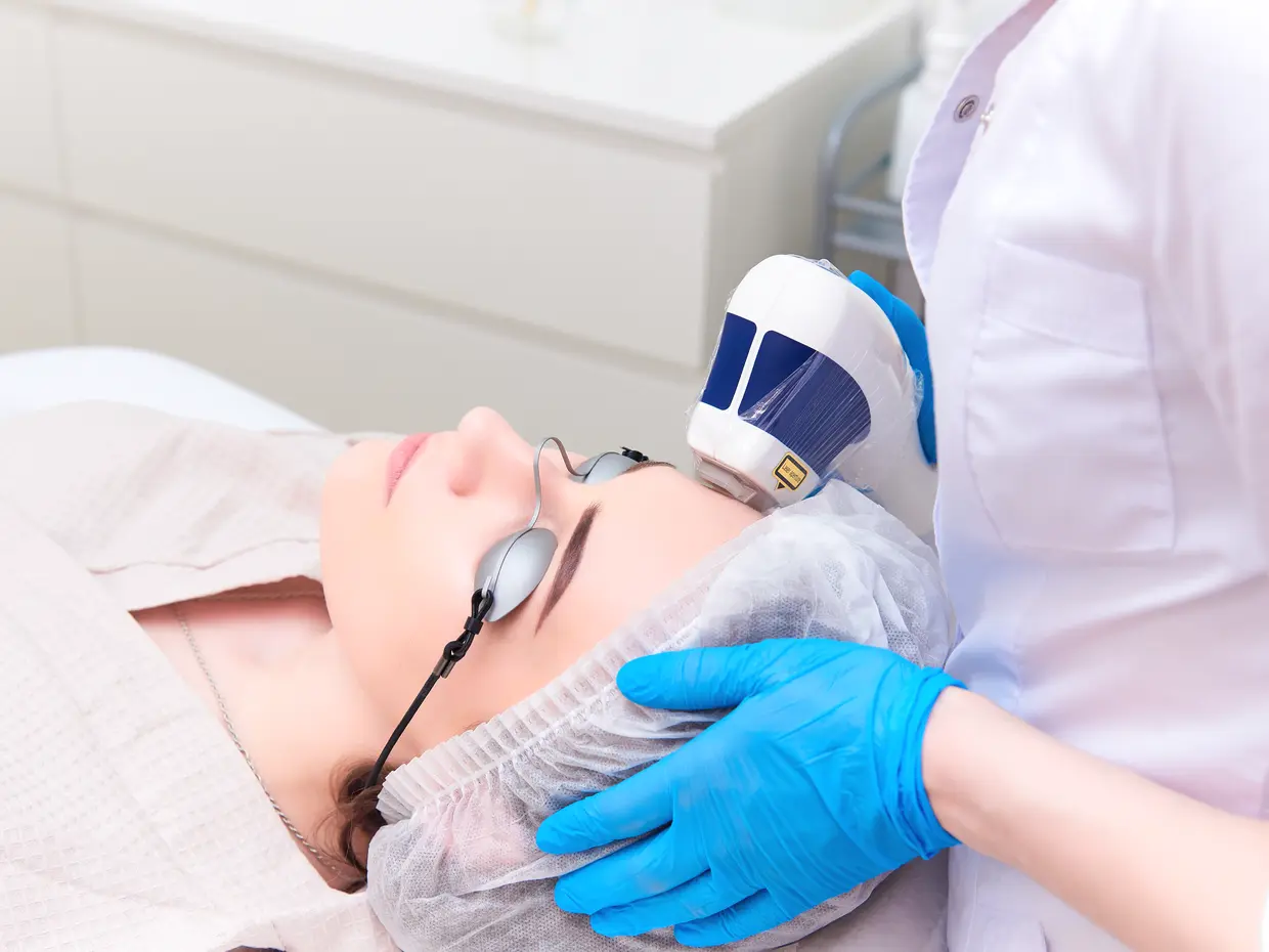 laser treatment on woman's face in spa